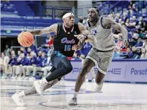  ?? Michael Wyke/Associated Press ?? Florida Atlantic guard Alijah Martin, left, drives past Rice’s Sam Alajiki during the second half of Wednesday night’s game.