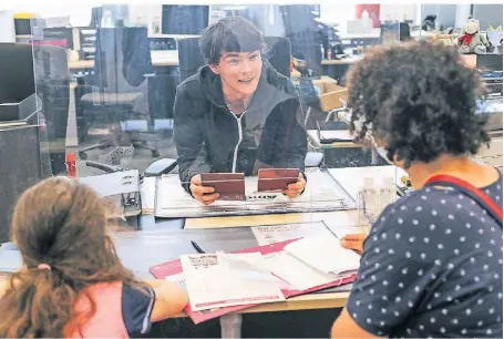  ?? FOTO: HANS-JÜRGEN BAUER ?? Leon Greven stellt für eine Bürgerin einen Kinderreis­epass aus. Sie hatte keinen regulären Termin bekommen und kam im Pop-up-Bürgerbüro rasch an die Reihe.