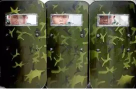  ??  ?? young children peering through sight windows of protective shields.