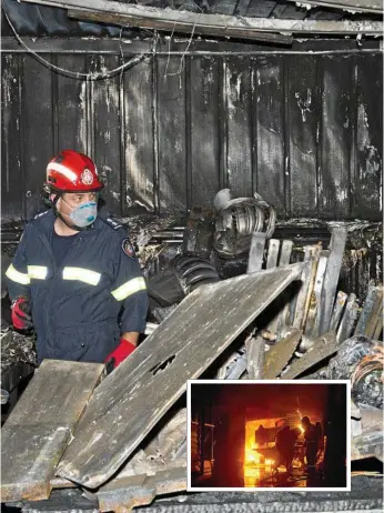 ?? Photos: Nev Madsen ?? NOTHING LEFT: Queensland Fire and Emergency Services Inspector David Zimmerle investigat­es the damage to Laurie Moore’s East Toowoomba shed after an inferno Tuesday night.