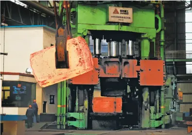  ?? AFP / Getty Images ?? Chinese employees walk past red-hot metal at a steel plant in Zouping in China’s eastern Shandong province. Stiff new U.S. tariffs on steel and aluminum could start a trade war with China, many analysts say.