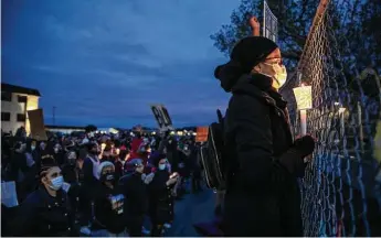  ?? Victor J. Blue / New York Times ?? People gather Thursday night in front of the police station in Brooklyn Center, Minn., to protest the death of Daunte Wright, a 20-year-old Black man who was fatally shot by an officer Sunday during a traffic stop.