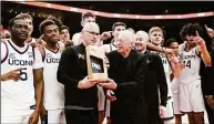  ?? Rick Bowmer / Associated Press ?? The UConn Huskies pose with Nike founder Phil Knight, center left, after winning the championsh­ip against Iowa State at the Phil Knight invitation­al on Sunday in Portland, Ore.