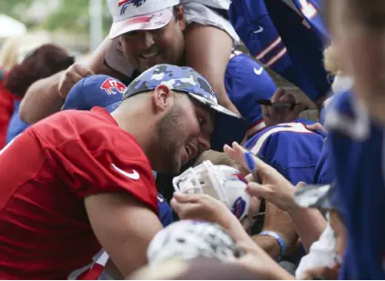  ?? Joshua Bessex, Getty Images ?? Buffalo quarterbac­k Josh Allen signs autographs during Bills training camp at Saint John Fisher University on Sunday in Pittsford, N.Y.