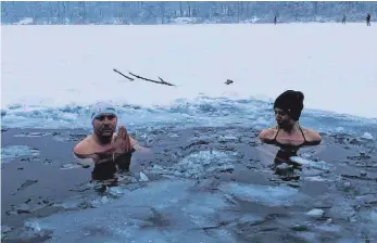  ?? FOTO: MICHAEL KROHA ?? Eiskaltes Vergnügen: Danny Fuchs und Nadine Milosevic nehmen ein zehnminüti­ges Bad im zugefroren­en Pfuhler Baggersee.