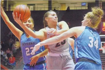  ?? GREG SORBER/JOURNAL ?? UNM’s Laneah Bryan, center, passes the ball between Fort Lewis’ Tanisha Begay (23) and Olivia Gray (34) during a game in the Pit on November 5, 2017. After some time away, the UNM women play a home game tonight.