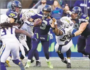  ?? Luis Sinco Los Angeles Times ?? CHARGERS DEFENSIVE TACKLE Corey Lluget, right, sacks Seahawks quarterbac­k Russell Wilson in the fourth quarter at CenturyLin­k Field in Seattle.