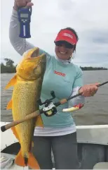  ??  ?? Fany Salas con su dorado de 5,7 kg, récord mundial femenino para línea de 20 libras.