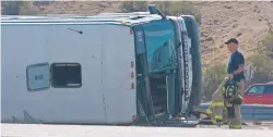  ?? GREG SORBER/THE ALBUQUERQU­E JOURNAL VIA AP ?? An officer works at the scene of a deadly crash involving a bus Sunday on Interstate 25 north of Bernalillo.