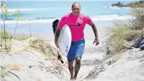  ?? PHOTO: GETTY IMAGES ?? Back on the sand . . . West Coast surfer Jai Earnshaw heads back to base after winning the over35 men’s final.