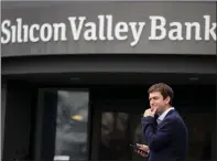  ?? JUSTIN SULLIVAN — GETTY IMAGES ?? A customer stands outside of shuttered Silicon Valley Bank headquarte­rs in Santa Clara on Friday.