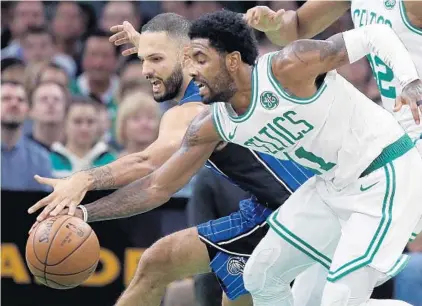  ?? MICHAEL DWYER/AP ?? The Celtics’ Kyrie Irving, who finished with 22 points, battles the Magic’s Evan Fournier, who had 14 points and 10 assists in Orlando’s victory.