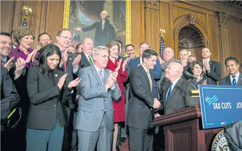  ??  ?? Rep Kevin Brady (R-Texas) and House Speaker Paul Ryan (R-Wis), centre, shake hands during a news conference with other House Republican­s at the Capitol Thursday.