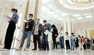  ?? /Reuters ?? Making sense of it: Journalist­s line up to pick up a copy of the population census report by China’s National Bureau of Statistics before a news conference in Beijing.