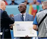  ?? ROLEX DELA PENA ?? CAMEROON’S Roger Milla gets an honour for being the oldest World Cup scorer from FIFA President Gianni Infantino at the Al Janoub Stadium in Al Wakrah, Qatar, on Thursday. Milla scored the winning goal against Argentina in the 1990 World Cup, one of the biggest upsets in World Cup history. | EPA