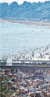  ??  ?? Crowded: The scene on the beach in Bournemout­h, Dorset, after the UK officially recorded its warmest day of the year so far.