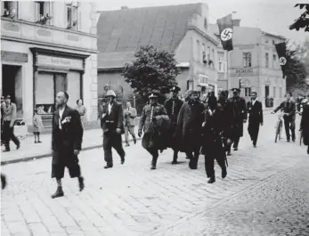  ?? Foto: archiv Petra Procházky ?? Před mnichovsko­u dohodou Náměstí ve Zlatých Horách 22. září 1938. Odvádění zajatých příslušník­ů četnické stanice. Vpravo uprostřed v dlouhém plášti jde velitel stanice.