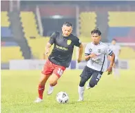  ??  ?? CUBA BOLOS: Pemain Sarawak United FC Sandro Da Silva cuba melepasi pemain Terengganu FC II.