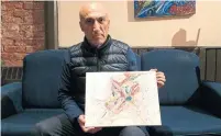  ?? WENDY GILLIS/TORONTO STAR ?? Selim Esen's brother, Ferhat Cinar, holds a painting his brother began but never finished.