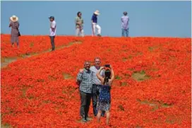  ?? AP PHOTO/MARCIO JOSE SANCHEZ ?? Visitors pose April 10 in a field of blooming flowers near the Antelope Valley California Poppy Reserve in Lancaster, Calif.