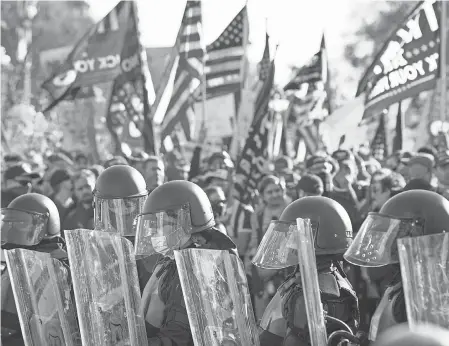  ?? JACK GRUBER/ USA TODAY ?? Supporters of President Donald Trump clashing with counterpro­testers near the Supreme Court building during the Million MAGA March in Washington, D. C., in November. Local police have stepped up precaution­s this week, including putting up signs saying open carry of guns is illegal in the district.