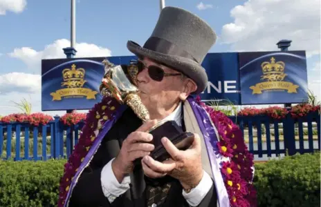  ?? MICHAEL BURNS/THE CANADIAN PRESS ?? Outspoken owner Kenneth Ramsey kisses the winner’s trophy after his colt, Sir Dudley Digges, won the 157th running of the Queen’s Plate.