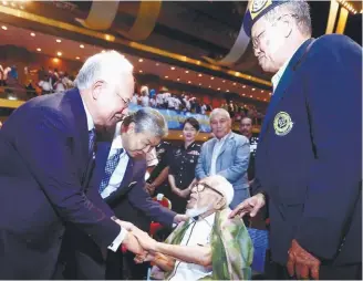  ?? BBXPIX ?? Najib and Ahmad Zahid speaking to a former policeman during the Police Retirees Assembly in Putra World Trade Centre yesterday.