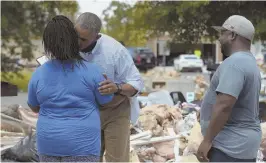  ?? AP PHOTO ?? WELCOME: President Obama gives Melissa Williams a kiss as her husband, LeRoy Williams, watches, during Obama’s tour of Castle Place, a flood-damaged area of Baton Rouge, La., yesterday.