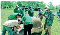  ??  ?? Wildlife officials examine the dead tusker