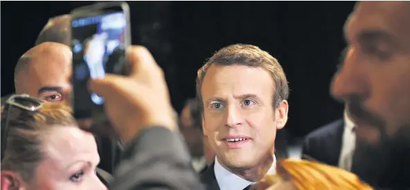  ??  ?? Emmanuel Macron posing for a phone picture: the so-called rebel is an ‘énarque’ who became a millionair­e working for a multi-national bank and was a minister in the last French government