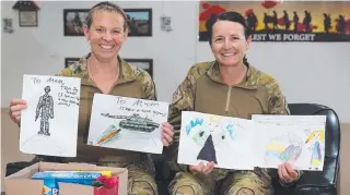  ?? Australian Army soldiers Major Kerryn Munday and Corporal Jaye Griffin from Task Group Taji 4 open care packages from their children before Mother’s Day at the Taji Military Complex, Iraq. ??