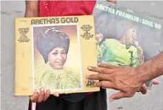  ??  ?? A fan holds up albums outside the New Bethel Baptist Church to pay his respects to the late Aretha Franklin in Detroit, Michigan on Saturday. The funeral for the legendary singer will be held on Aug 31 in her hometown Detroit, local media reported, citing family sources. — AFP photo