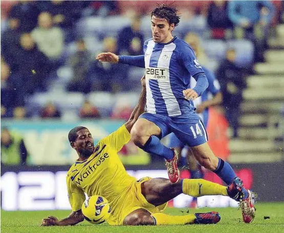  ??  ?? Going through: Wigan’s Jordi Gomez (right) is tackled by Reading’s Mikele Leigertwoo­d during their English Premier League match on Saturday. Gomez went on to score a hat-trick in Wigan’s 3-2 win.