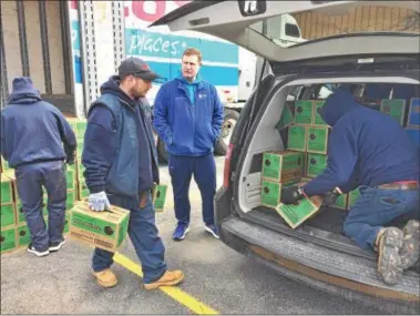  ?? PHOTOS BY GLENN GRIFFITH — GGRIFFITH@DIGITALFIR­STMEDIA.COM ?? Curtis Strife, center in light blue, watches as cases of Thin Mints are loaded into his car Friday.