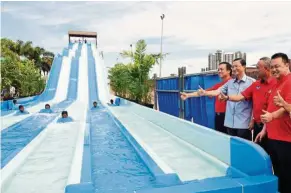  ??  ?? Tee (second from left) with Austin Heights group of companies founder and managing director Datuk Steve Chong (left) giving their approval to one of the slides available at the Austin Heights Water and Adventure Park in Johor Baru in December 2015.