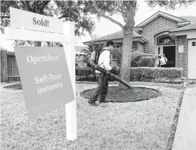  ?? Michael Wyke / Contributo­r ?? Antonio Rodriguez, center, and his cousin, Bairo, with CLS Landscapin­g and Maintenanc­e, complete the weekly lawn services on a home owned by Opendoor.