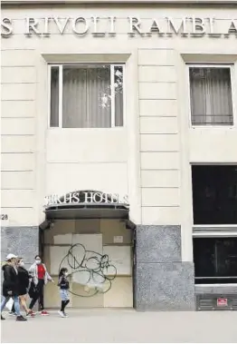  ?? Álvaro Monge ?? Un grup de persones passa davant l’hotel Serhs Rivoli Rambla, tancat.