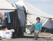  ?? (Rodi Said/Reuters) ?? A BOY WHO FLED Raqqa stands outside a tent on Monday at a camp in Ain Issa, north of the Syrian city.