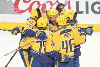  ??  ?? Nashville Predators left wing Filip Forsberg (9) is congratula­ted after scoring an empty-net goal against Pittsburgh on Monday during Game 4 of the Stanley Cup Final in Nashville. The Predators’ agressive style, which they liken to that of a junkyard...