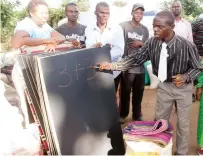  ?? ?? A teacher writes on a blackboard, one of the several donated by First Lady Dr Auxillia Mnangagwa in 2018 as he demonstrat­es how he is going to teach learners in the Doma community who were used to writing on the ground