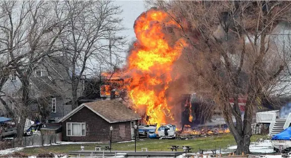  ?? FOTO’S REUTERS ?? Het vuur laait hoog op nadat William Spengler maandag brand heeft gesticht in Webster, in de Amerikaans­e staat New York. De man schoot twee toegesneld­e brandweerm­annen dood. Drie andere hulpverlen­ers raakten gewond.