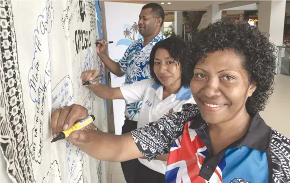  ?? Photo: Ronald Kumar ?? Tuli Cirivakaya­wa (from right), Salanieta Marama and Ramisese Saunivalu write their message on the COP23 Masi in support of climate change at My FNPF centre on October 10, 2017.