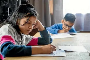  ??  ?? Rika Gautam, 11, left, and Rithem Sanjel, 11, sit their end-of-year Nepalese language exam.