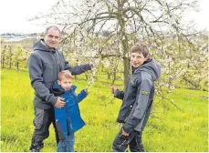  ??  ?? Bauen viel Obst an: Florian Stocker mit zwei seiner drei Söhne, Jonathan (7) und Valentin (12).