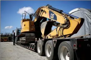  ?? Bloomberg News/LUKE SHARRETT ?? An employee checks a Caterpilla­r Inc. rental excavator loaded on a flatbed trailer at the Whayne Supply Co. dealership in Lexington, Ky., on Oct. 17. Caterpilla­r on Tuesday reported a third-quarter profit of $283 million.