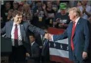  ?? CAROLYN KASTER — THE ASSOCIATED PRESS FILE ?? Ohio state Sen. Troy Balderson, left, the Republican candidate running to succeed former Republican U.S. Rep. Pat Tiberi in Ohio’s 12th District, clasps hands with President Donald Trump as Balderson speaks during a rally at Olentangy Orange High School in Lewis Center.