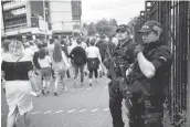  ?? OLI SCARFF/GETTY IMAGES ?? Armed police officers secure the area as revellers arrive Saturday to attend a concert at Old Trafford cricket ground in Manchester, England.