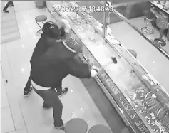  ??  ?? A CCTV image shows the robbery suspects striking the “bullet-proof” display counters in a futile attempt to steal the jewellery at a Shah Alam mall on Monday evening.