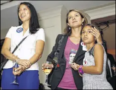  ?? TAMI CHAPPELL / CONTRIBUTE­D ?? Lillie Madali (from left), Gigi Pedraza and her daughter Shanti Rodriquez listen to Hillary Clinton’s speech accepting the nomination Thursday during a viewing event at The Commerce Club.