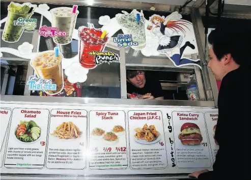  ?? DAMIAN DOVARGANES / THE ASSOCIATED PRESS ?? Okamoto Kitchen’s Gerald Abraham speaks with a customer from the window of his food truck in Beverly Hills, Calif. The truck employs a carefully chosen menu and avoids going to the same location too often to keep its concept fresh.